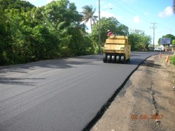 Dynapac rubberwheeel rolling freshly paved asphalt during the construction of the Choc to Gros Islet highway in St. Lucia.